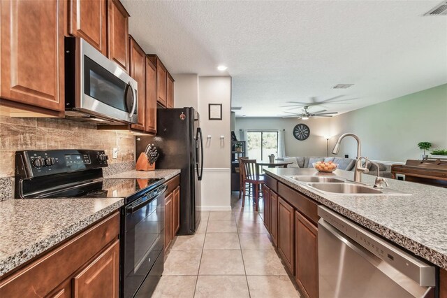 10148 Rose Petal Pl, Riverview, FL 33578 - kitchen with appliances with stainless steel finishes, a sink, open floor plan, tasteful backsplash, and visible vents