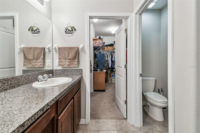 10148 Rose Petal Pl, Riverview, FL 33578 - bathroom with toilet, tile patterned floors, a spacious closet, and vanity