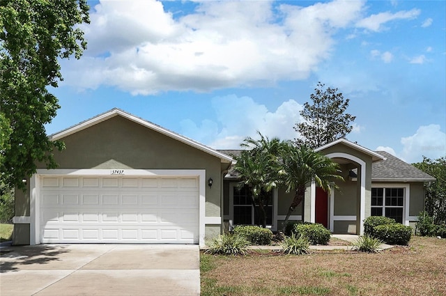 37437 Laurel Hammock Dr, Zephyrhills, FL 33541 - ranch-style house with concrete driveway, an attached garage, and stucco siding