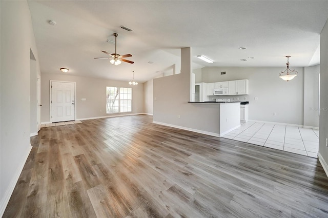37437 Laurel Hammock Dr, Zephyrhills, FL 33541 - unfurnished living room with ceiling fan, visible vents, lofted ceiling, and light wood-type flooring