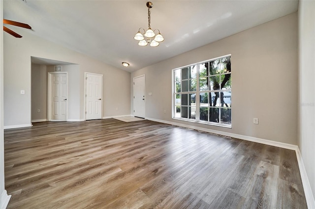 37437 Laurel Hammock Dr, Zephyrhills, FL 33541 - interior space with baseboards, vaulted ceiling, wood finished floors, and ceiling fan with notable chandelier