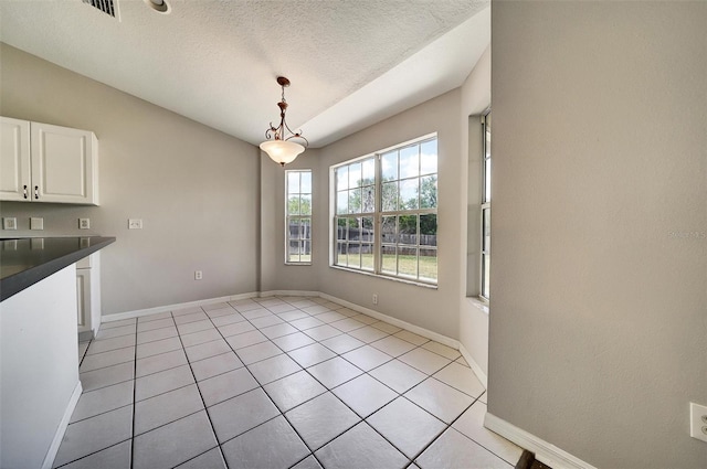 37437 Laurel Hammock Dr, Zephyrhills, FL 33541 - unfurnished dining area featuring visible vents, baseboards, a textured ceiling, and light tile patterned floors