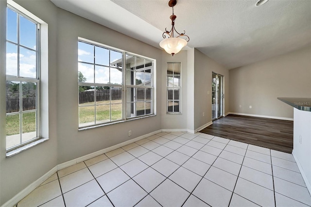 37437 Laurel Hammock Dr, Zephyrhills, FL 33541 - unfurnished dining area with a textured ceiling, baseboards, and tile patterned flooring