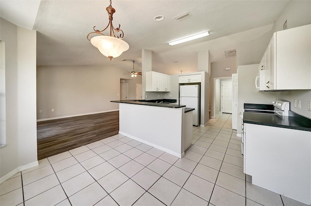 37437 Laurel Hammock Dr, Zephyrhills, FL 33541 - kitchen featuring dark countertops, light tile patterned floors, vaulted ceiling, and white appliances