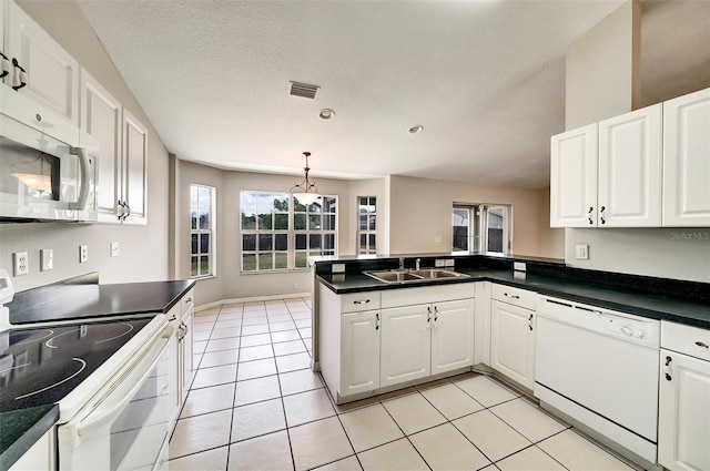 37437 Laurel Hammock Dr, Zephyrhills, FL 33541 - kitchen featuring white cabinets, a sink, white appliances, a peninsula, and visible vents