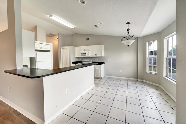 37437 Laurel Hammock Dr, Zephyrhills, FL 33541 - kitchen featuring dark countertops, vaulted ceiling, baseboards, white cabinets, and white appliances