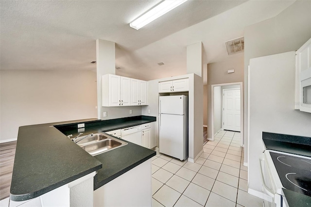 37437 Laurel Hammock Dr, Zephyrhills, FL 33541 - kitchen with white cabinets, dark countertops, white appliances, a peninsula, and visible vents