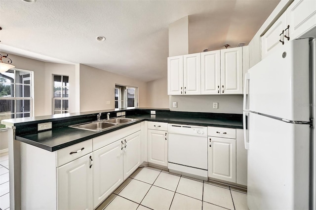 37437 Laurel Hammock Dr, Zephyrhills, FL 33541 - kitchen with a peninsula, dark countertops, white appliances, and a sink