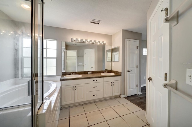 37437 Laurel Hammock Dr, Zephyrhills, FL 33541 - bathroom featuring a sink, double vanity, a bath, and visible vents
