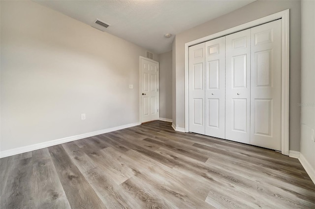 37437 Laurel Hammock Dr, Zephyrhills, FL 33541 - unfurnished bedroom with baseboards, a closet, wood finished floors, and visible vents
