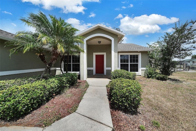 37437 Laurel Hammock Dr, Zephyrhills, FL 33541 - view of exterior entry with a shingled roof and stucco siding