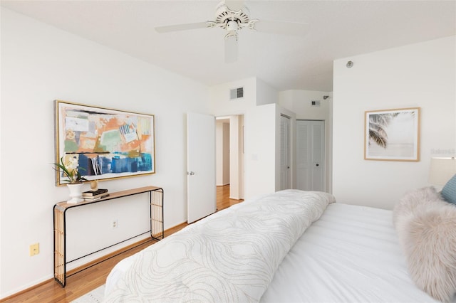 bedroom with a ceiling fan, a closet, visible vents, and wood finished floors