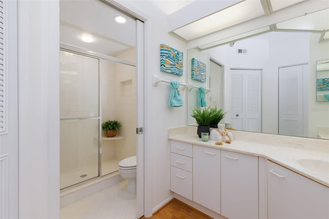 bathroom with toilet, vanity, visible vents, recessed lighting, and a shower stall