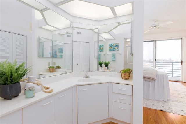 full bathroom featuring vanity, ensuite bathroom, a closet, and wood finished floors