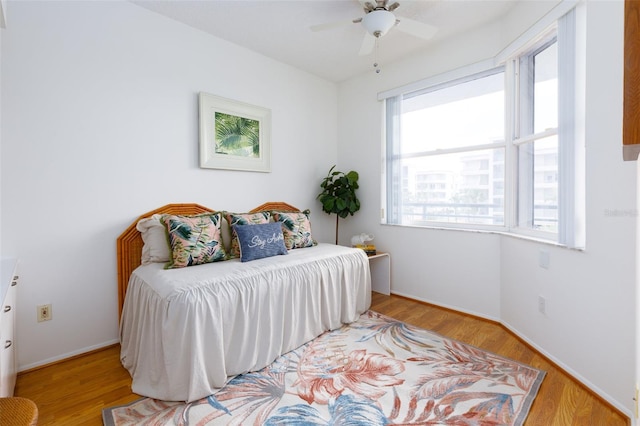 bedroom featuring wood finished floors, baseboards, and ceiling fan