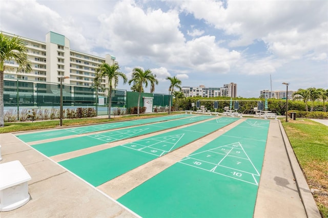 view of home's community featuring fence and shuffleboard