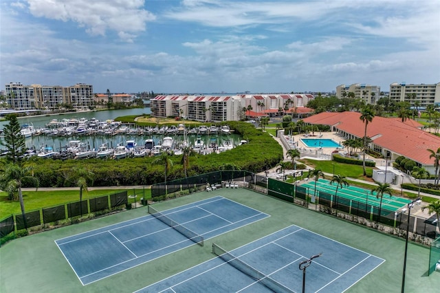 view of sport court with a water view and fence