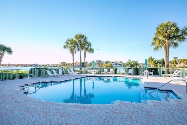 community pool featuring fence and a patio