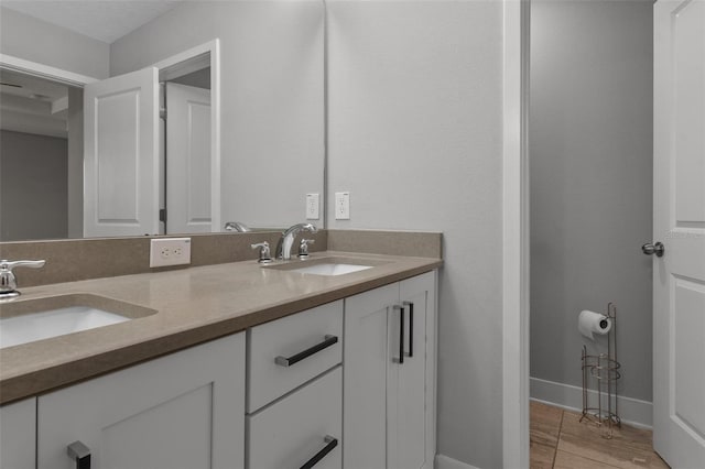 bathroom with double vanity, a sink, baseboards, and wood finished floors