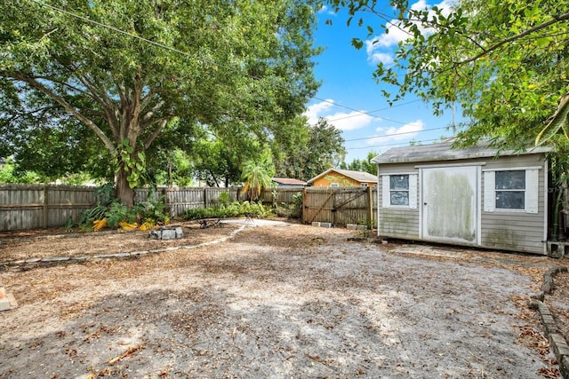 view of yard featuring a storage shed, an outbuilding, and a fenced backyard