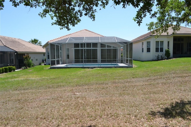 rear view of property with an outdoor pool, stucco siding, a tiled roof, a lawn, and a lanai