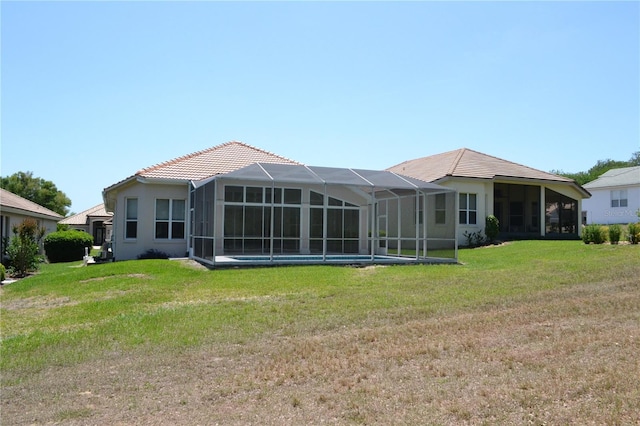 rear view of property with glass enclosure, a yard, a tile roof, and an outdoor pool