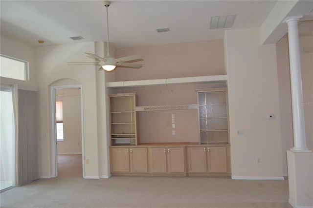unfurnished living room featuring a ceiling fan, visible vents, light carpet, and ornate columns