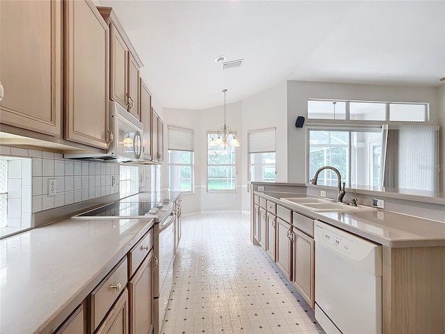 kitchen with backsplash, a sink, baseboards, a notable chandelier, and white appliances