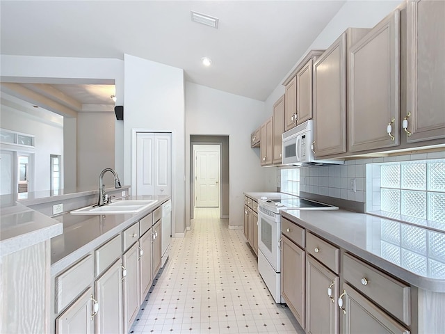 kitchen featuring visible vents, a sink, baseboards, light floors, and white appliances