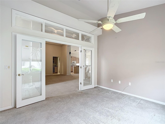spare room with french doors, baseboards, carpet, and a ceiling fan