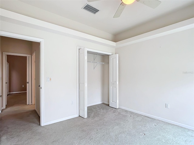 unfurnished bedroom with baseboards, light colored carpet, visible vents, and a closet