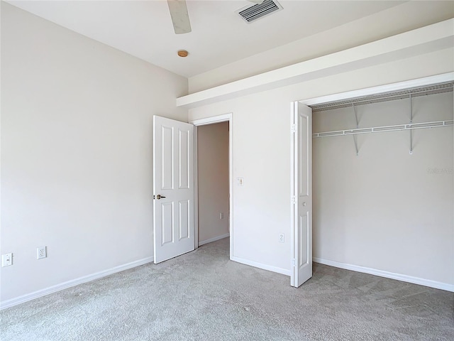 unfurnished bedroom with a ceiling fan, visible vents, carpet floors, baseboards, and a closet