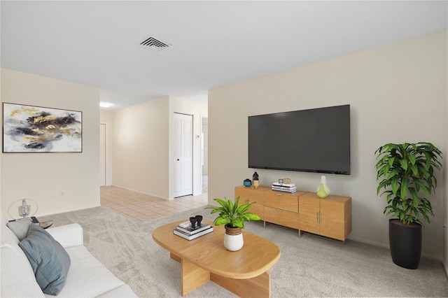 living room featuring baseboards, visible vents, and light carpet
