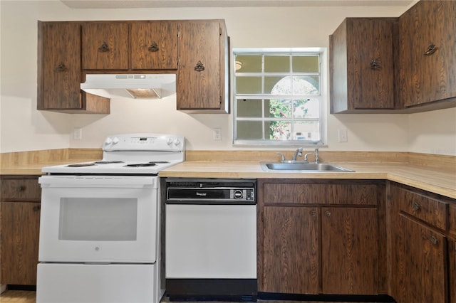 kitchen featuring light countertops, under cabinet range hood, white appliances, and a sink