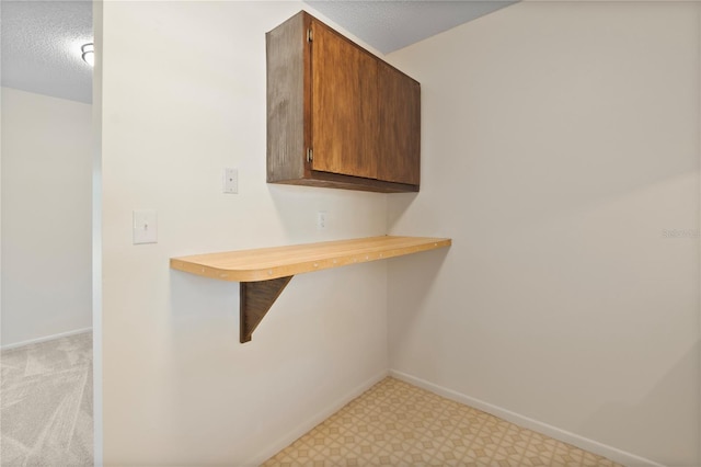 interior space featuring a textured ceiling, baseboards, and tile patterned floors