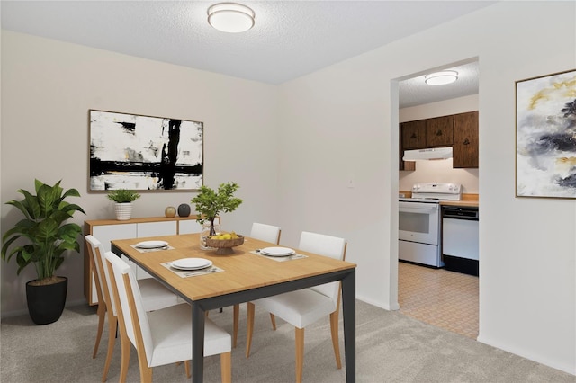 dining area featuring a textured ceiling and light carpet