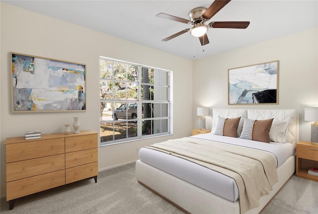 bedroom with baseboards, a ceiling fan, and light carpet