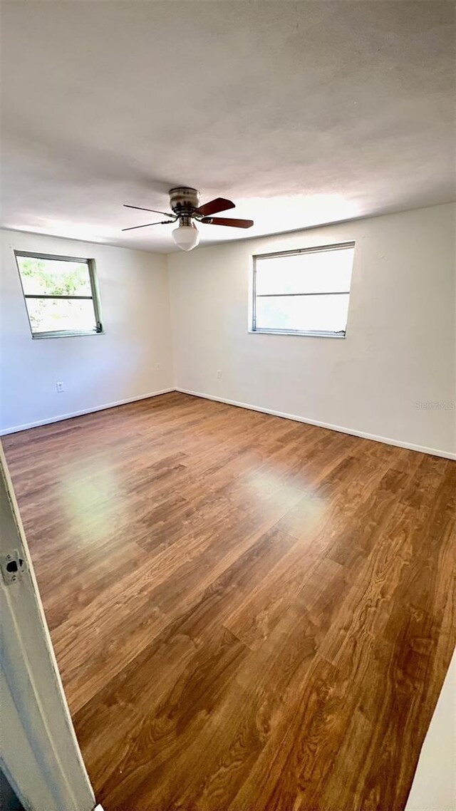 7734 Judith Cres, Port Richey, FL 34668 - unfurnished room with a ceiling fan, a healthy amount of sunlight, and wood finished floors