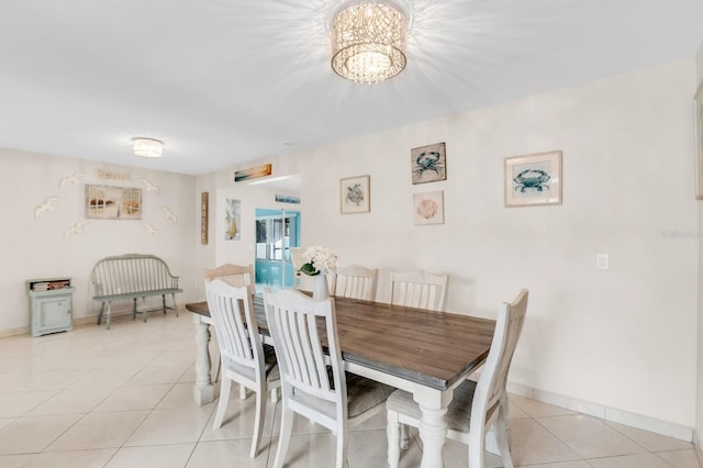 1403 Garden Ave, Tarpon Springs, FL 34689 - dining space featuring light tile patterned flooring, a chandelier, and baseboards