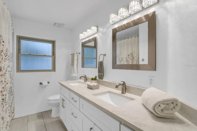 1403 Garden Ave, Tarpon Springs, FL 34689 - bathroom featuring tile patterned floors, toilet, double vanity, and baseboards