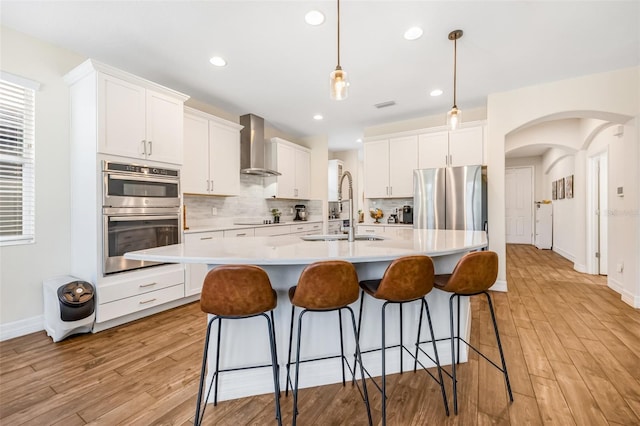 4808 Jackson Club Loop, Tampa, FL 33624 - kitchen with stainless steel appliances, wall chimney exhaust hood, light wood finished floors, decorative backsplash, and recessed lighting