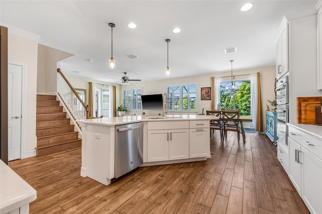 4808 Jackson Club Loop, Tampa, FL 33624 - kitchen with stainless steel appliances, wood finished floors, light countertops, white cabinets, and recessed lighting