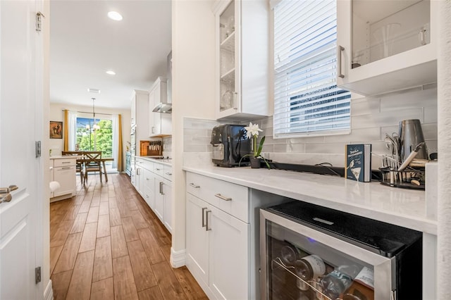 4808 Jackson Club Loop, Tampa, FL 33624 - kitchen with wine cooler, light wood-style floors, white cabinets, tasteful backsplash, and recessed lighting