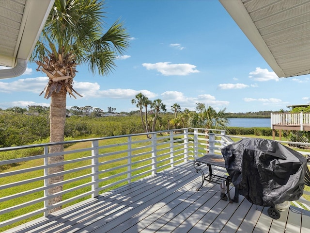 deck with grilling area and a water view