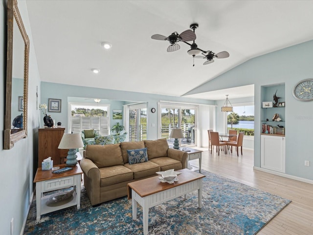 living room with a ceiling fan, baseboards, vaulted ceiling, and wood finished floors