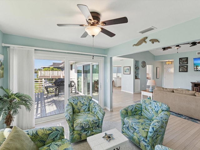 living area featuring ceiling fan, french doors, visible vents, baseboards, and light wood-style floors