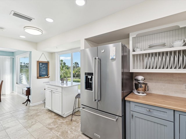 kitchen with visible vents, open shelves, high end fridge, tasteful backsplash, and gray cabinetry