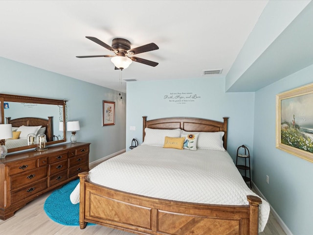 bedroom with baseboards, ceiling fan, light wood finished floors, and visible vents