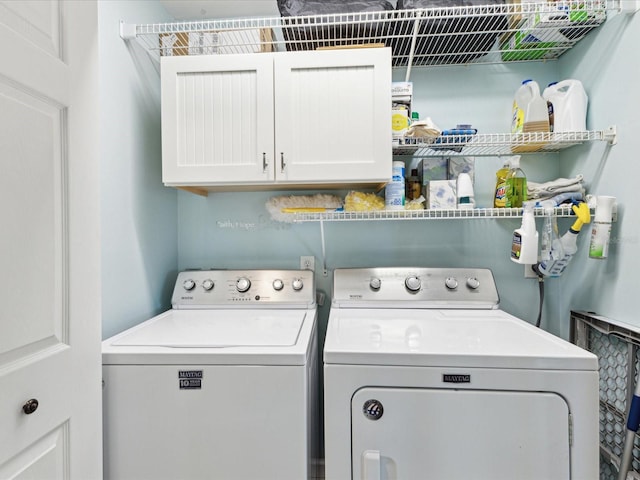 laundry area featuring washing machine and dryer and cabinet space