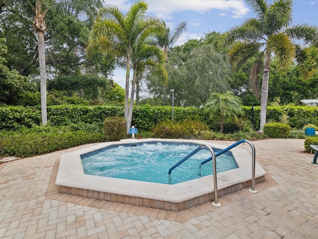 view of swimming pool featuring a patio and an in ground hot tub